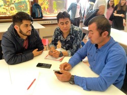 Drei Herren sitzen an einem Tisch und unterhalten sich