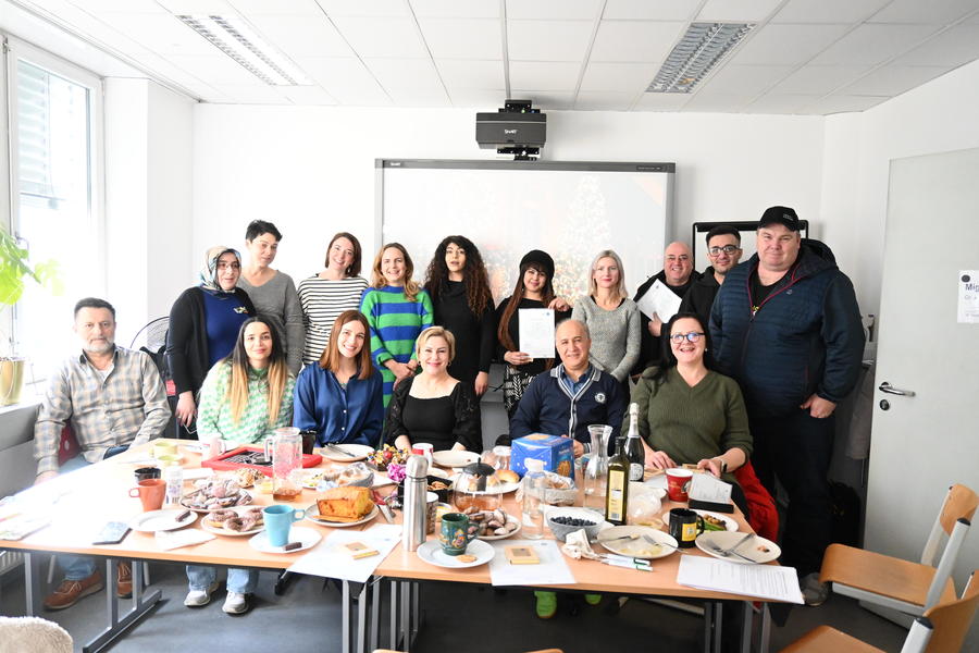 Ein Gruppenfoto vor der Klassentafel von den Teilnehmer*innen und dem Team
